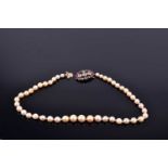 A mid 20th century cultured pearl necklace, fastened with a yellow metal, garnet, quartz, and