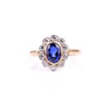 An 18ct yellow gold, diamond, and sapphire cluster ring, set with a mixed oval-cut sapphire (