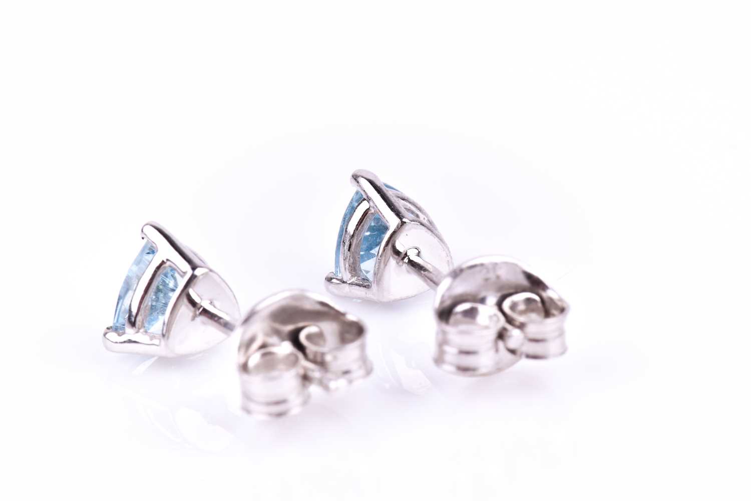 A pair of 9ct white gold and aquamarine ear studs, each set with a trillion-cut aquamarine, each 5 x - Image 2 of 2