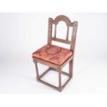 An 18th century oak single chair, with carved frame and turned supports, later solid seat and