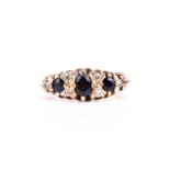 An 18ct yellow gold, diamond, and sapphire ringset with an oval-cut and two round-cut sapphires, and