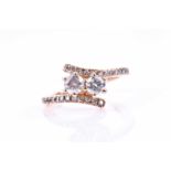 A 14ct rose gold and diamond crossover ring, set with two round-cut diamonds of approximately 0.30