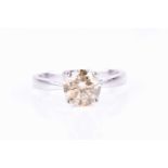 An 18ct white gold and champagne diamond ring, set with a solitaire diamond of approximately 1.40