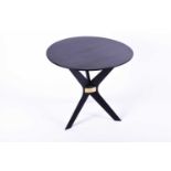 A Birgit Israel ebonised side table, the plain circular top supported on boomerang shaped legs, with