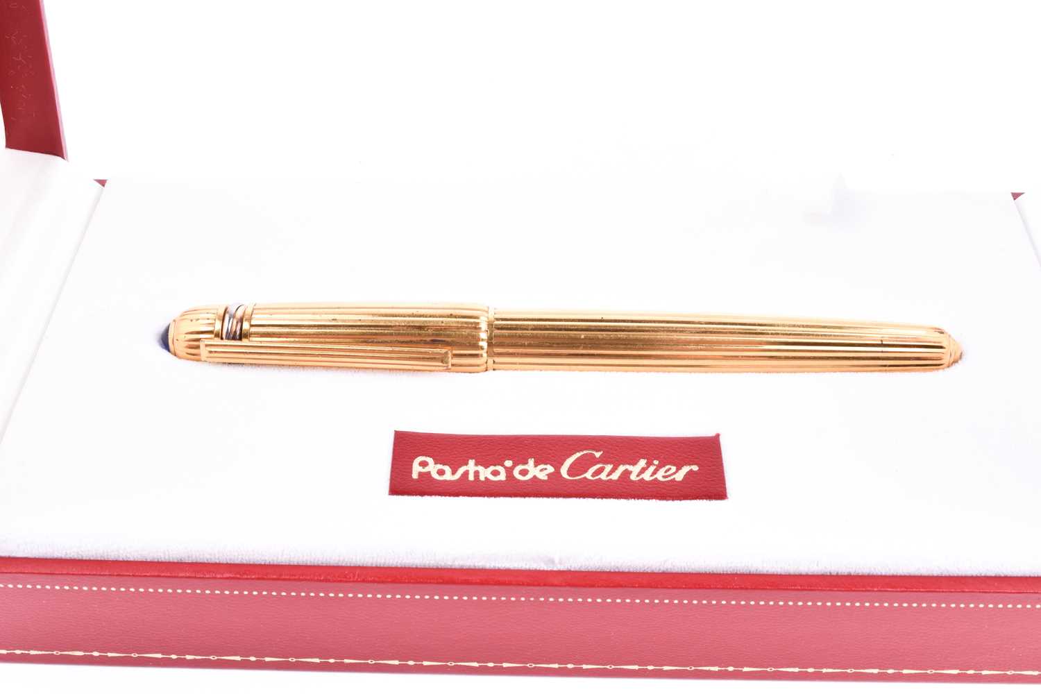 Pasha de Cartier. A gold plated fountain pen, with 18k nib, the body with ribbed decoration, the lid