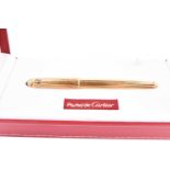 Pasha de Cartier. A gold plated fountain pen, with 18k nib, the body with ribbed decoration, the lid