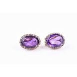 A pair of yellow metal, amethyst, and white sapphire cluster earrings, each set with a mixed oval-