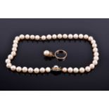 A pearl necklace, formed of creamy white cultured pearls, 38 cm long, fastened with a yellow metal