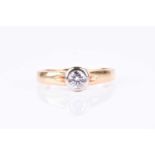 An 18ct yellow gold and diamond ring, the bezel set round brilliant-cut diamond of approximately 0.