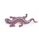 A silver gilt, diamond, and ruby brooch in the form of a lizard, set with round-cut rubies and