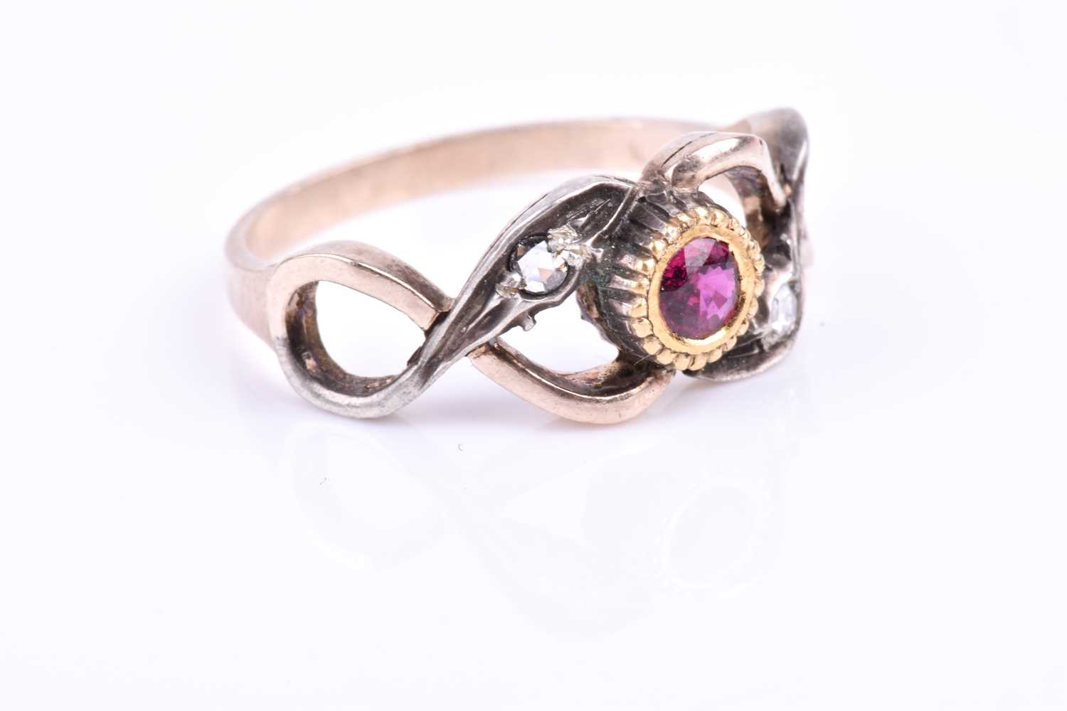 A yellow metal, silver, diamond, and ruby ring, centred with a mixed round-cut ruby in a yellow gold - Image 2 of 3