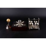 Three golf-themed novelty items, comprising a silver plated four cup egg set on stand, with