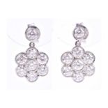 A pair of 18ct white gold and diamond daisy cluster earrings, each daisy set beneath a collet-set