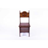 A Victorian mahogany metamorphic library chair, the back with carved roundel, and solid seat,