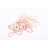 A group of five various strands of freshwater pearls, including pink and white examples, unstrung.
