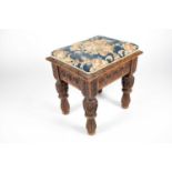 An Edwards and Roberts carved oak stool, with upholstered floral seat, maker's plaque underneath, 48