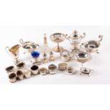 A collection of mixed silver items, comprising eight napkin rings, a five-piece condiment set, two