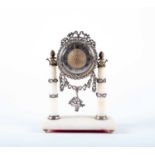 A French late 19th century silver and semi-precious stone set miniature clock, supported on a
