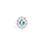 An 18ct white gold, diamond, and emerald ring, set with a mixed oval-cut emerald of approximately