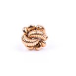 A yellow metal cocktail ring of knotted design, the stylised mount with rope-twist decoration, the