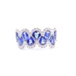 An 18ct white gold, diamond and sapphire ring, the rounded mount set with a row of mixed pear-cut