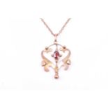 An Art Nouveau 9ct yellow gold and garnet drop pendant, suspended on a yellow metal chain (chain a/