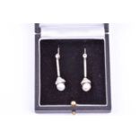 A pair of diamond and pearl drop earrings, each with a collet-set old-cut diamond, above a