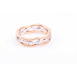 An 18ct tri-coloured gold and diamond band ring, formed of three waved lines of yellow, white, and