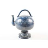 An unusual European pottery cadogan teapot, late 19th century, in a deep blue glaze with repeating
