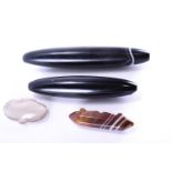 Two large polished agate oval pendants, principally black in colour with fine white and brown bands,