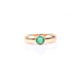 An 18ct yellow gold and emerald ring, bezel set with a round-cut emerald, approximately 4.5 mm
