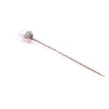 A gentleman's tie pin, set with a natural freshwater pearl, in a diamond mount, yellow metal pin