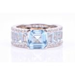 A diamond and blue topaz cocktail ring, set with a mixed square-cut topaz, the shoulders channel-set