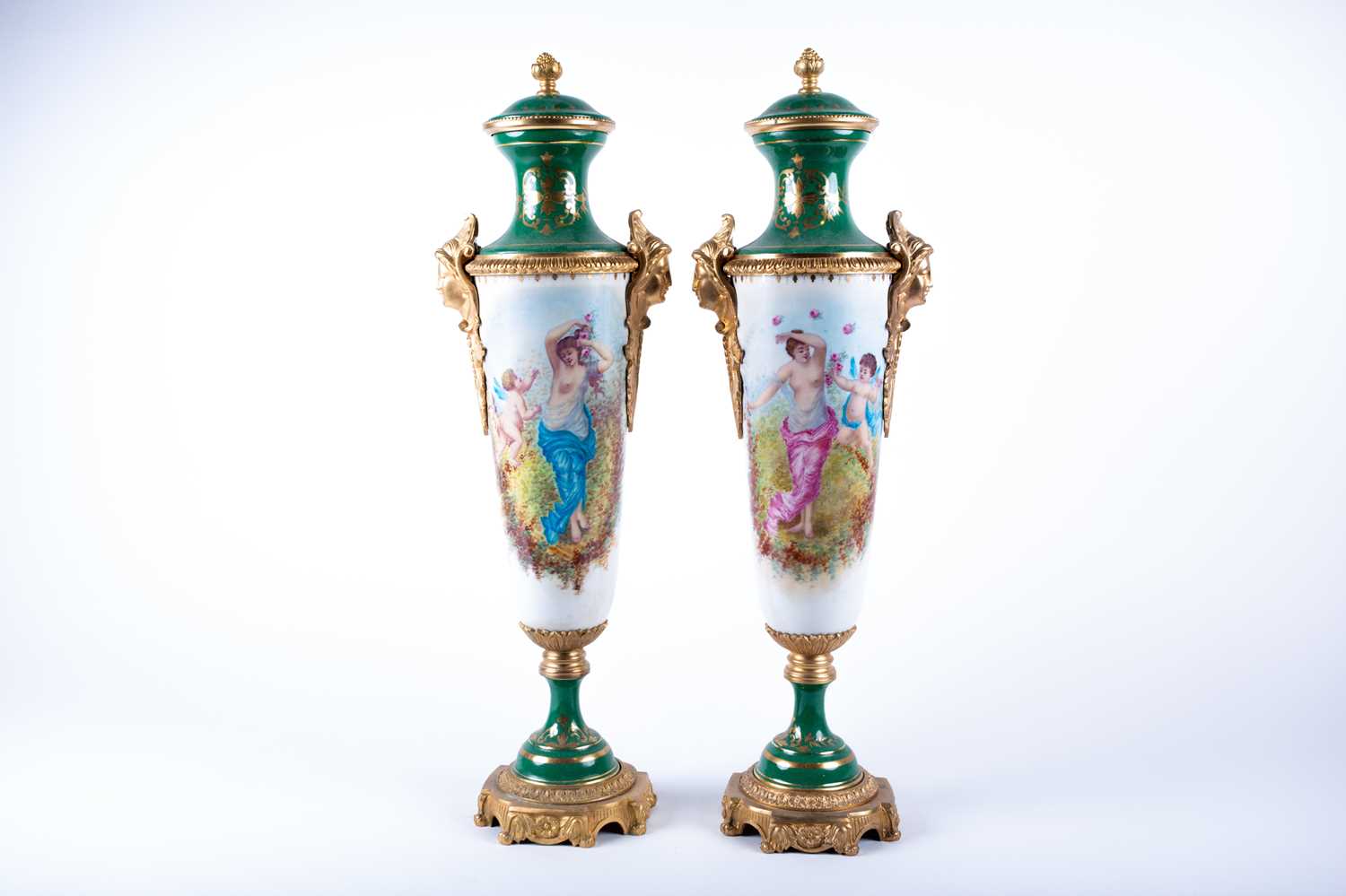 A pair of Sevres style porcelain vases and covers, the green painted covers with gilt flower