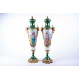 A pair of Sevres style porcelain vases and covers, the green painted covers with gilt flower