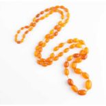 An opera length amber beaded necklace comprised of graduated oval beads, the largest approximately