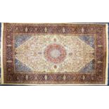 A large Persian rug, 20th century, with central medallion on a principally red ground framed by