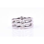 A white metal and diamond triple band ring, inset with three round brilliant-cut diamonds of