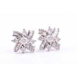 A pair of 9ct white gold and diamond earrings, the crossed design inset with round-cut and tapered