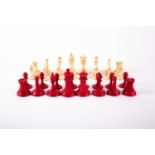 A Staunton style carved and turned bone chess set, 19th century, natural and red stained, the