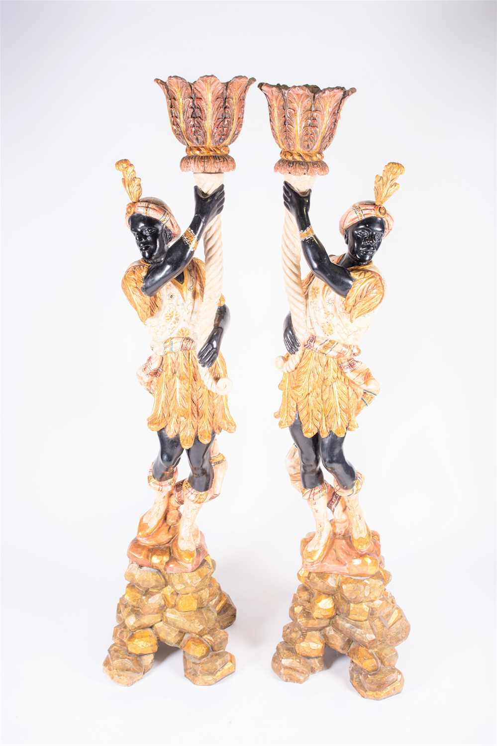 A pair of large 20th century blackamoors, wood carved with bright polychrome decoration, each