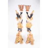 A pair of large 20th century blackamoors, wood carved with bright polychrome decoration, each