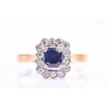 An 18ct yellow gold, diamond, and sapphire cluster ring, set with a rectangular-cut sapphire