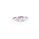 A three stone diamond ring, the round brilliant cut diamonds in tiered four claw mounts to a plain