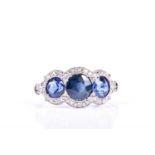 An Art Deco three stone sapphire and diamond half hoop ring, the three slightly graduated circular