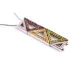 An unusual white gold, diamond, pink and yellow sapphire, and demantoid garnet pendant of abstract