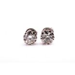 A pair of solitaire diamond ear studs, set with round brilliant-cut diamonds of approximately 1.50