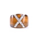 A yellow metal, diamond, and tigers eye cocktail ring, the wide band inset with a diamond-set cross,