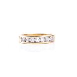 A seven stone half hoop diamond ring, the round brilliant cut diamond channel set to a plain band,