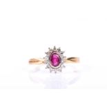 A ruby and diamond cluster ring, the oval cut ruby in rub over setting within a border of